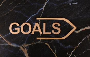 Inspiring image of a wooden 'GOALS' sign on a dark marble surface, symbolizing ambition.